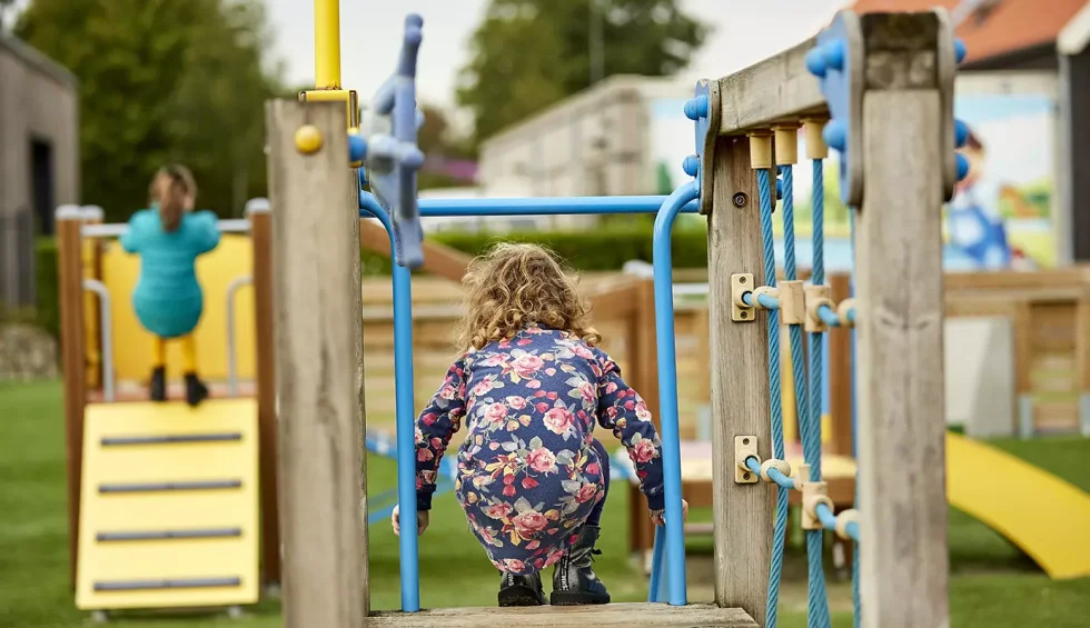 Kindje dat speeltoestel afklimt.webp