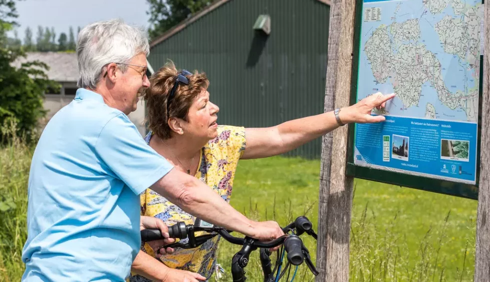 ouder-koppel-bekijkt-fietsroute.webp